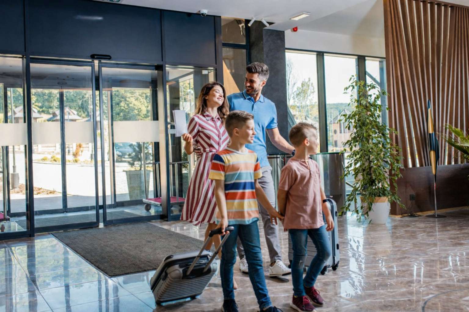 Family with luggage arriving at a bright hotel lobby