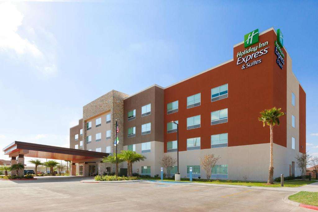 Holiday Inn Express & Suites Edinburg by day with red-brown facade, stone tower and covered entrance