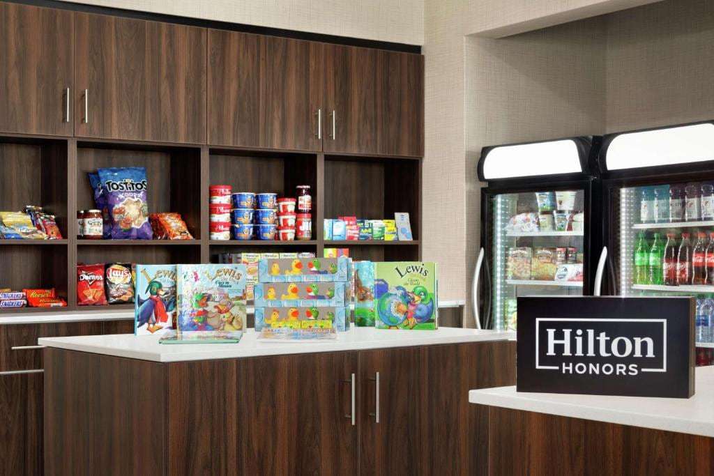 Suite shop with snacks, drink coolers, Homewood duck books and a Hilton Honors sign