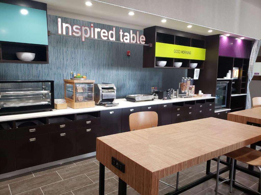 Inspired Table breakfast area with buffet counter, toaster, cereal dispensers and wood dining tables