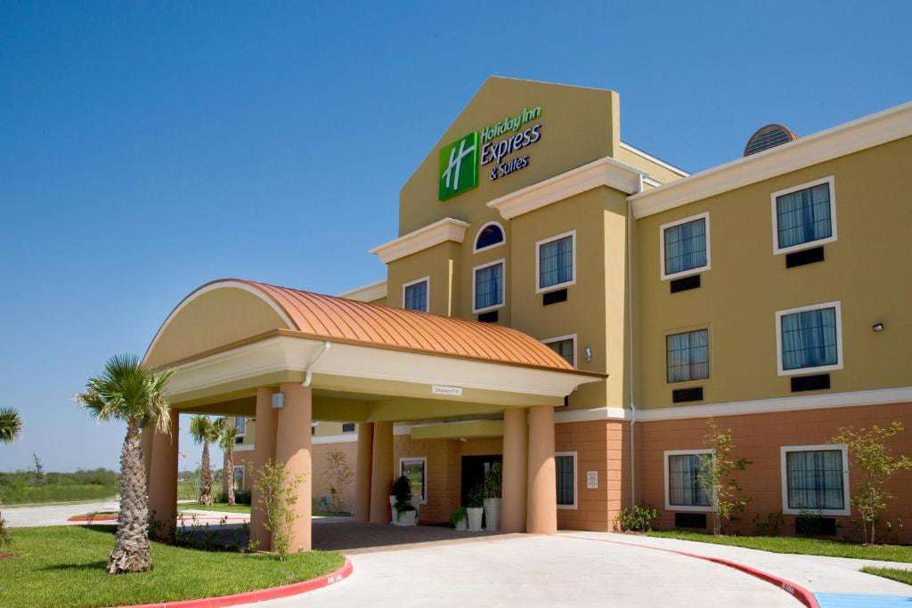 Hotel entrance with copper-roofed porte-cochere, palm trees and Holiday Inn Express & Suites sign