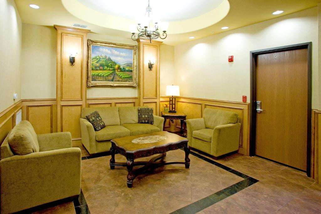 Lobby lounge with sofa, armchairs, carved wood coffee table and framed landscape painting