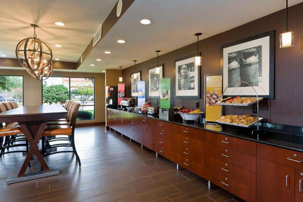 Breakfast area with buffet counter, bagels and fruit, and a high-top communal table