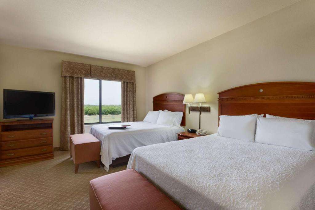 Guest room with two queen beds, flat-screen TV, dresser and window