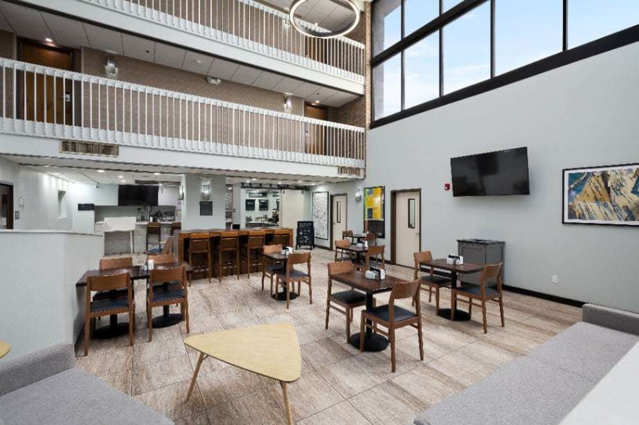 Atrium lobby with dining tables, sofas, a high-top bar and balconies on the upper floors