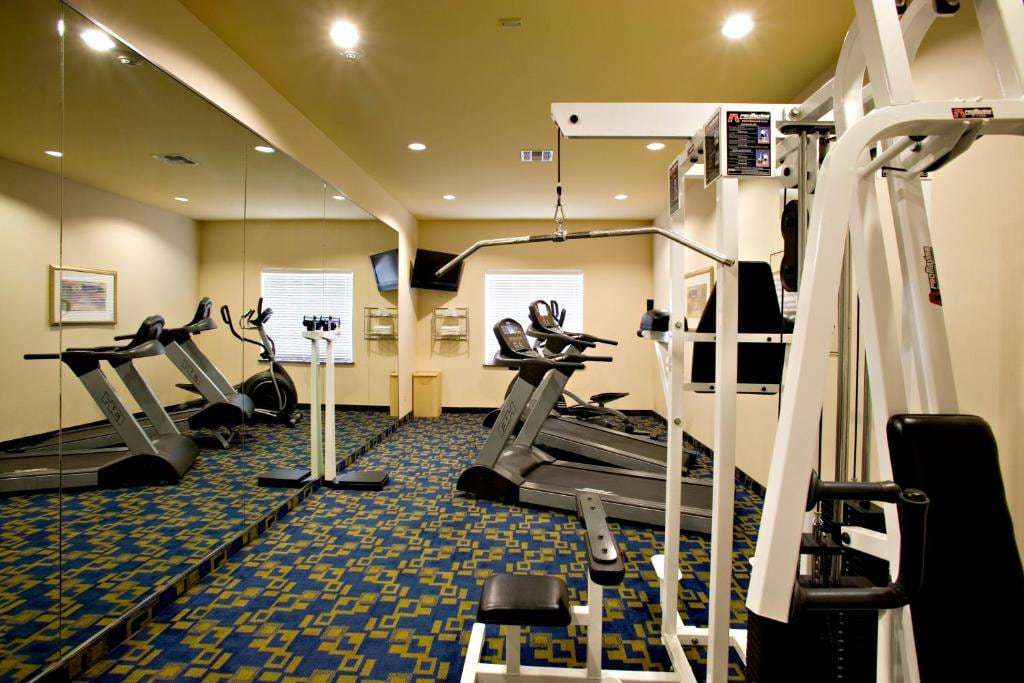 Fitness center with cable weight station, treadmills and wall-mounted TVs