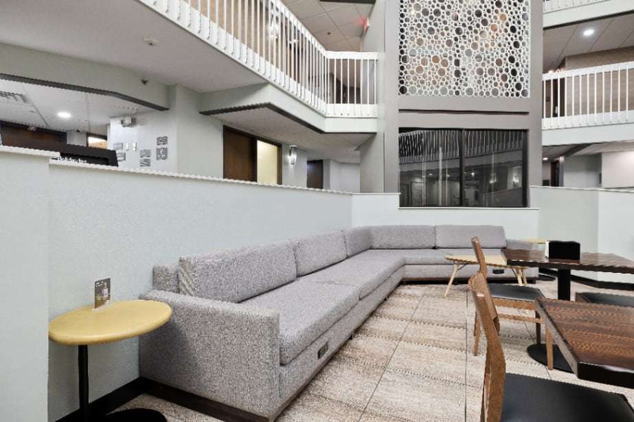 Gray sectional sofa and cafe tables in the atrium lounge below the balconies