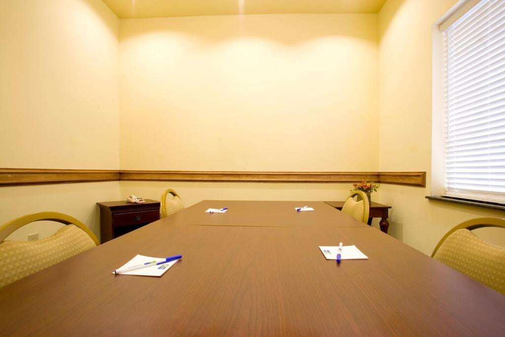 Small meeting room with conference table, upholstered chairs and notepads