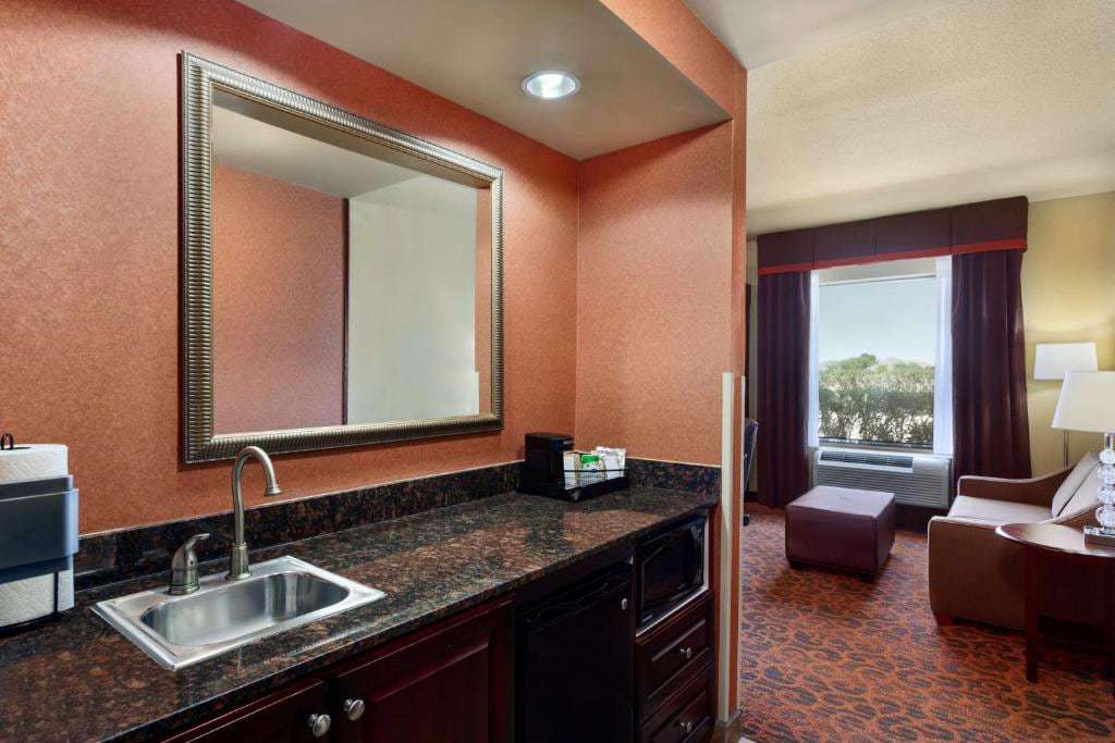 Suite wet bar with sink, microwave, mini fridge and coffee maker next to the sitting area