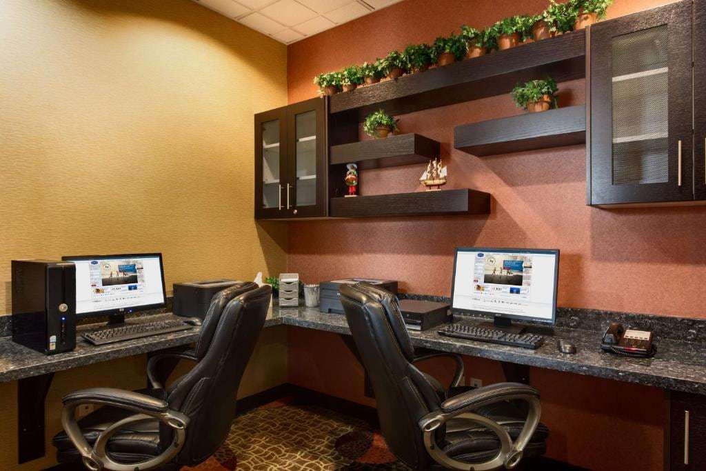 Business center with two computer workstations, printer and leather chairs