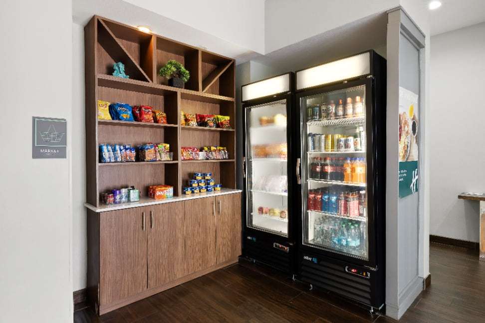 Lobby market with snack shelves and two refrigerated drink coolers