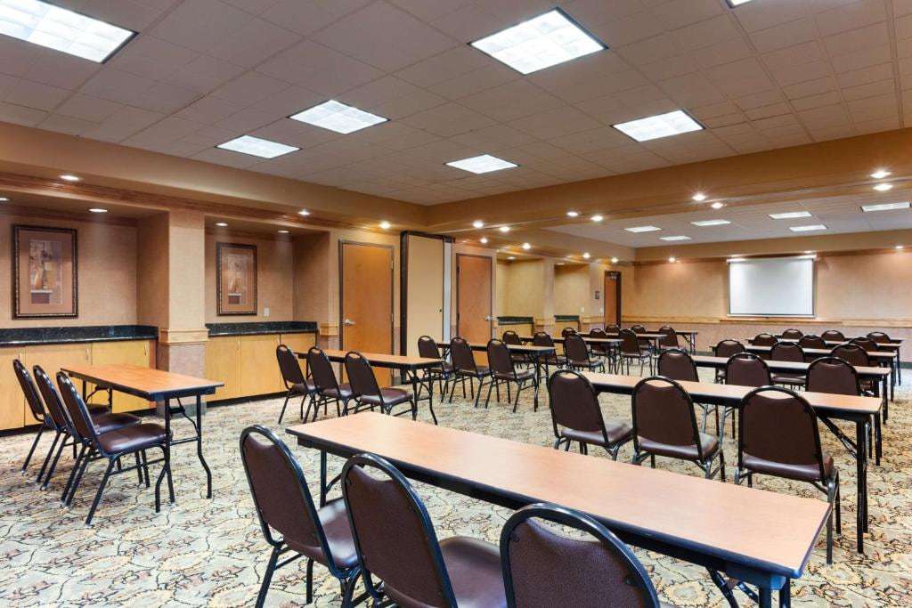 Meeting room set classroom-style with long tables, chairs and a projection screen