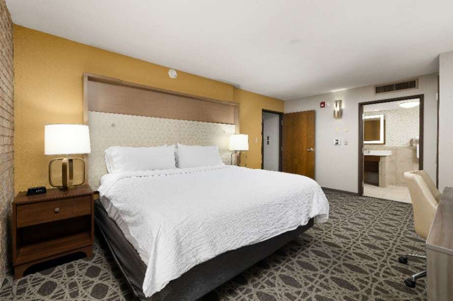 Accessible king room with wide floor space and an open door to a roll-under sink bathroom