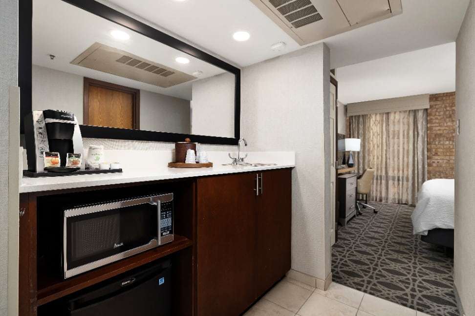 Suite wet bar with microwave, mini fridge and coffee maker, bedroom beyond