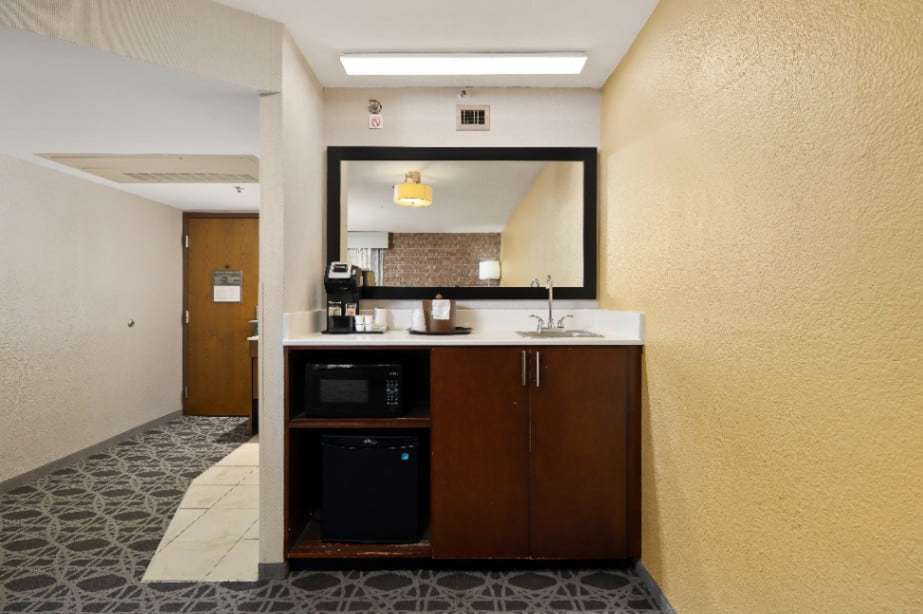 Wet bar with sink, microwave, mini fridge and coffee maker near the suite entry