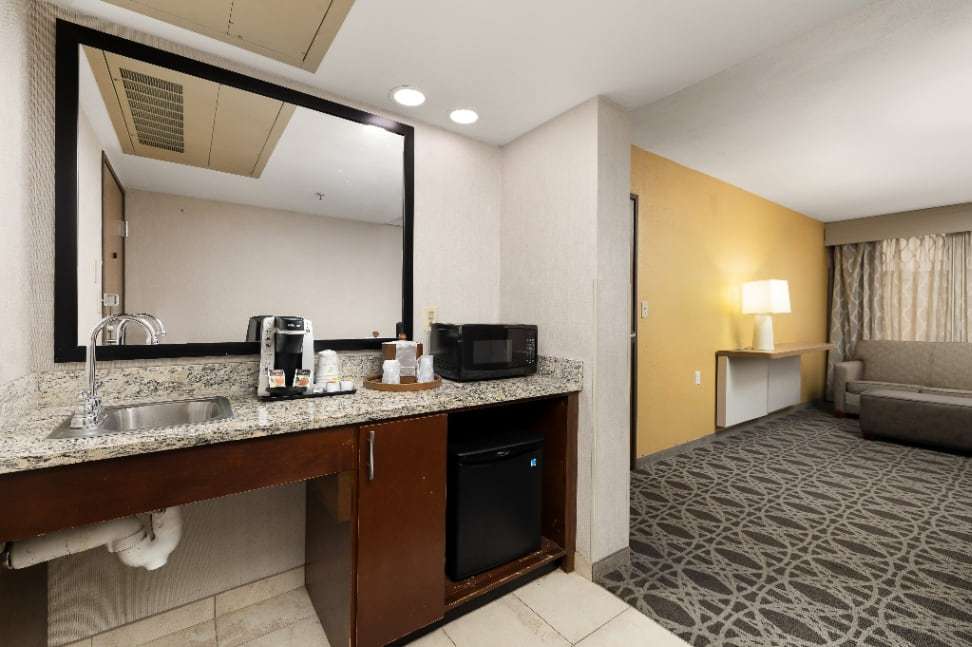 Accessible roll-under wet bar with sink, coffee maker and microwave, sitting area beyond