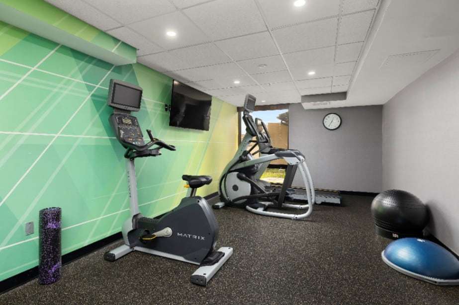 Fitness center with exercise bike, elliptical, stability balls and wall TV