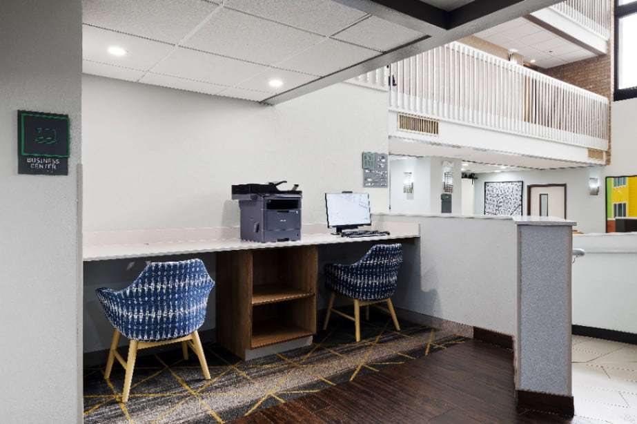 Business center with printer, computer and two patterned chairs