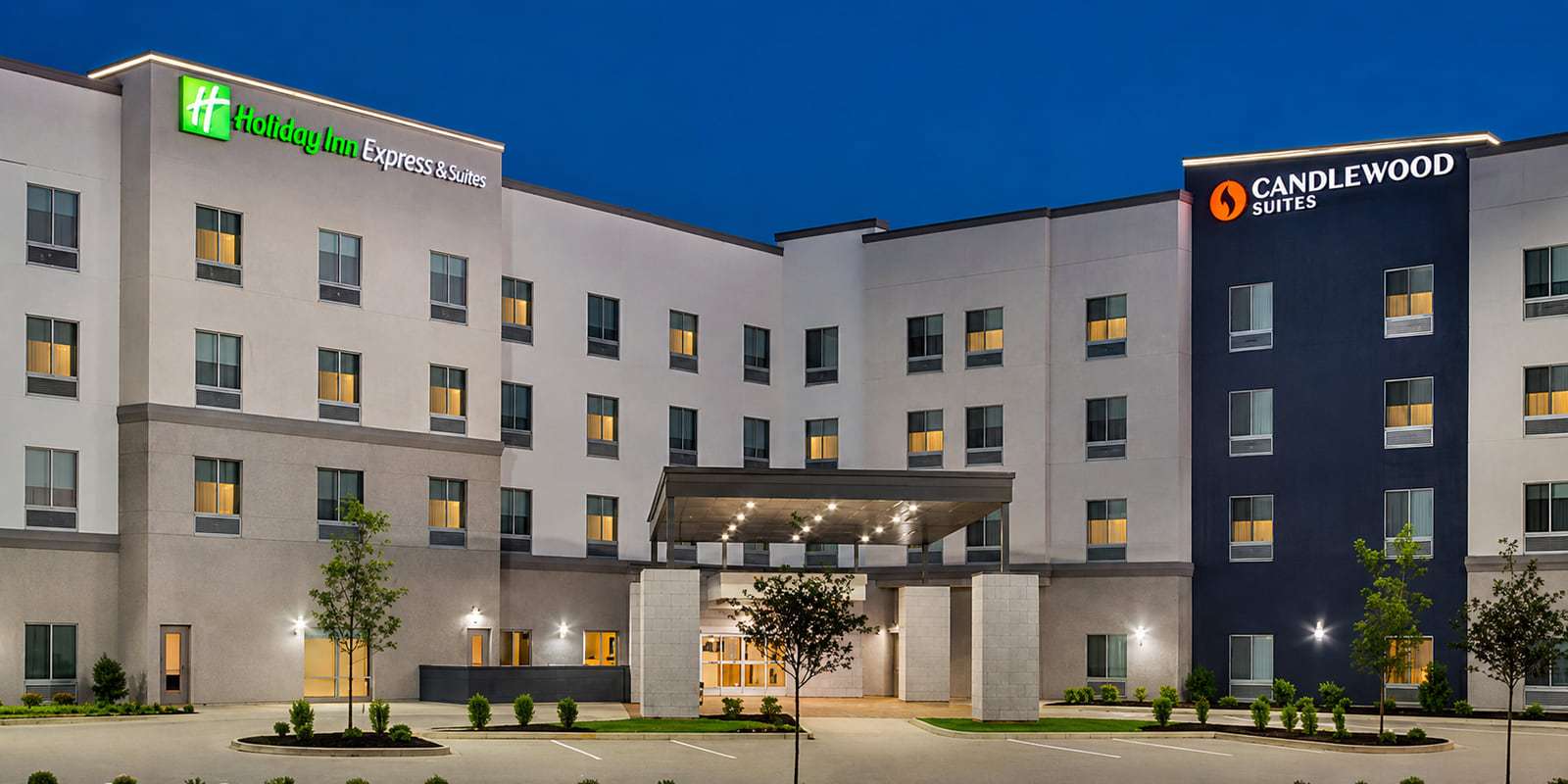 Four-story dual-brand Holiday Inn Express & Suites and Candlewood Suites hotel at twilight