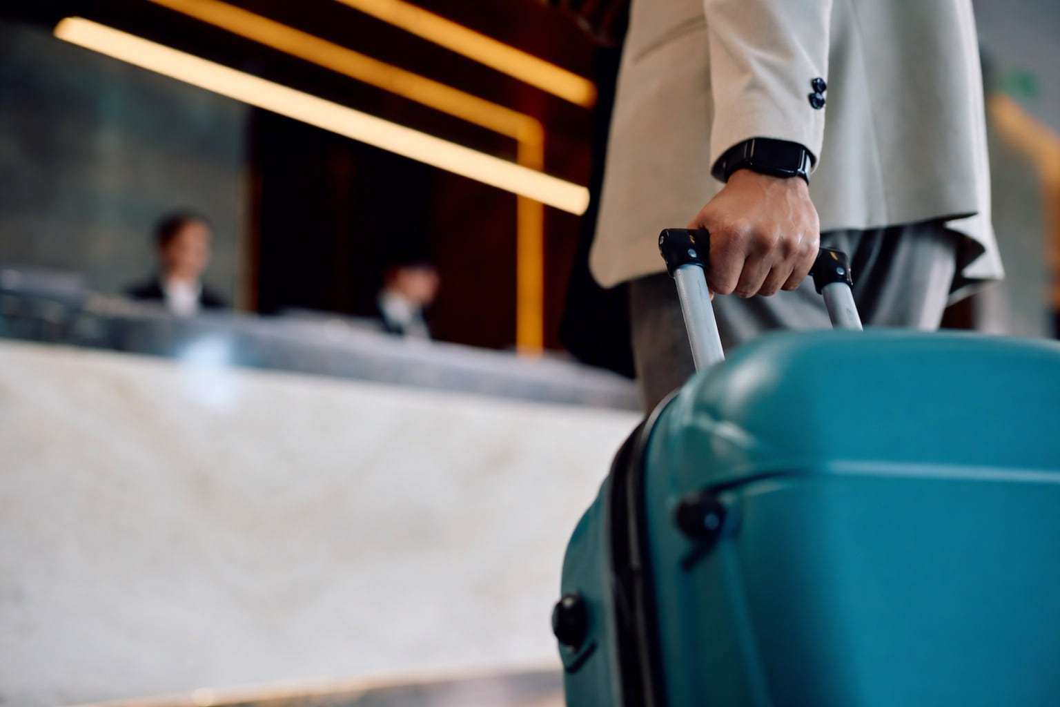 Guest with a suitcase checking in at a hotel front desk